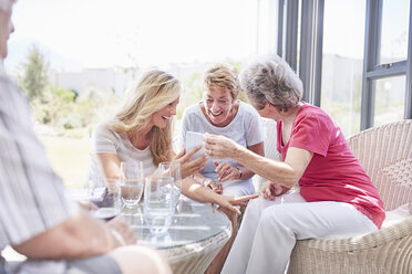 Senior women using cell phone on patio - CAIF11389