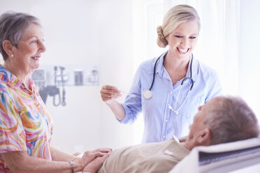 Smiling doctor checking senior man’s temperature - CAIF11390