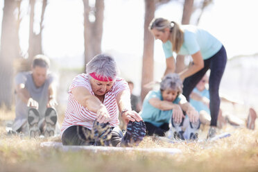 Ältere Erwachsene üben Yoga im sonnigen Park - CAIF11403