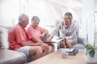 Finanzberater bespricht Papierkram mit älterem Ehepaar - CAIF11406