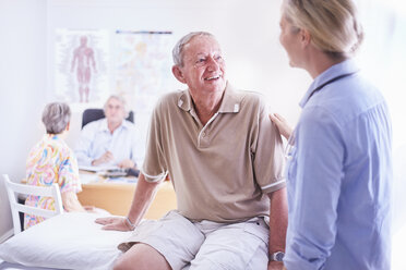 Arzt im Gespräch mit einem älteren Mann im Untersuchungsraum - CAIF11415