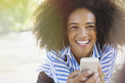 Begeisterte Frau, die mit Kopfhörern und mp3-Player Musik hört, lizenzfreies Stockfoto