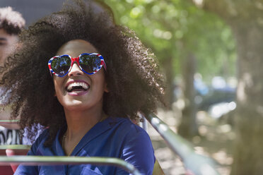 Enthusiastische Frau mit Afro und herzförmiger Brille - CAIF11440