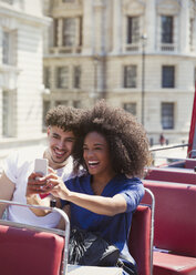 Couple taking selfie on double-decker bus - CAIF11444