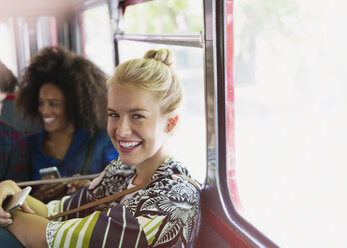 Porträt lächelnde blonde Frau im Bus - CAIF11448