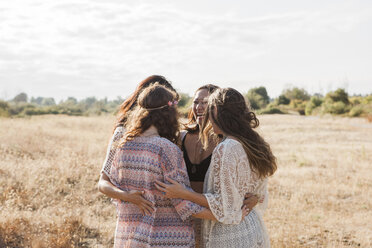 Boho women hugging in rural field - CAIF11467
