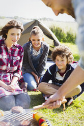 Familiengrillen auf dem sonnigen Campingplatz - CAIF11496