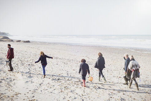 Mehrgenerationenfamilie beim Spaziergang am sonnigen Strand - CAIF11498