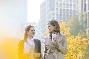 Geschäftsfrauen beim Spaziergang mit Kaffee in der Stadt - CAIF11555