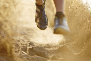Close up of runner’s feet on dirt trail - CAIF11569