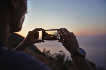 Mann fotografiert Sonnenuntergang Meerblick mit Kamera-Handy - CAIF11577