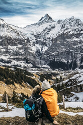 Couple looking at snowy mountain view, Grindelwald, Switzerland - CAIF11578