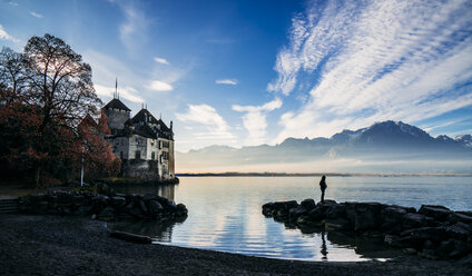 Mann auf Felsen am Seeufer vor dem Schloss Chillon, Schweiz - CAIF11584