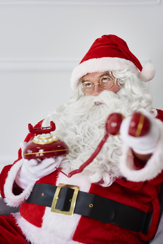 Porträt des Weihnachtsmannes mit Telefon, lizenzfreies Stockfoto