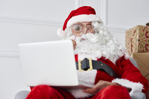 Santa claus using laptop with magnifier - ABIF00120