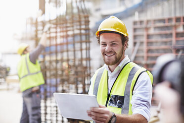 Portrait confident construction worker with digital tablet at construction site - CAIF11590