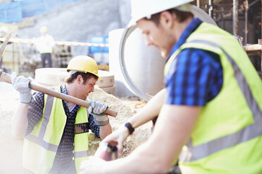 Construction workers digging at construction site - CAIF11601