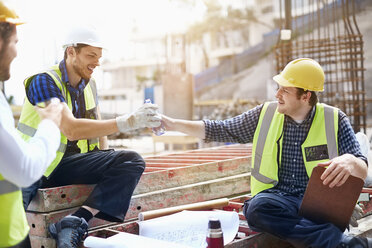 Construction workers and engineer enjoying coffee break at construction site - CAIF11605