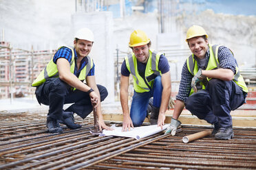 Porträt zuversichtlich Bauarbeiter und Ingenieur Überprüfung der Blaupause auf der Baustelle - CAIF11607