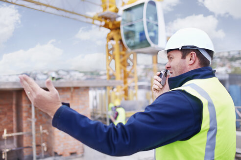 Bauarbeiter mit Walkie-Talkie auf einer Baustelle - CAIF11616