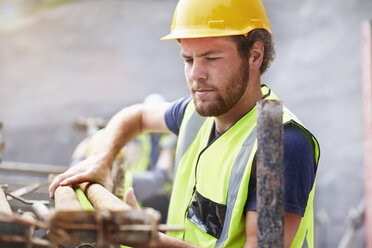 Construction worker lifting rebar - CAIF11627