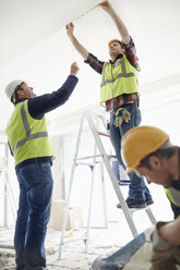 Construction worker on ladder at construction site - CAIF11634