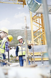 Construction workers assembling structure at highrise construction site - CAIF11648