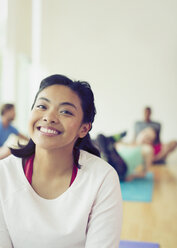 Porträt lächelnde Frau im Yoga-Kurs - CAIF11690