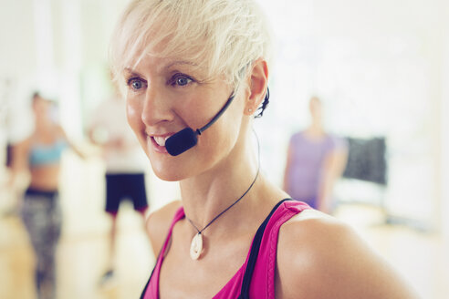 Lächelnder Fitnesstrainer mit Headset in Großaufnahme - CAIF11694