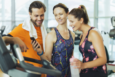 Friends using cell phone at gym stock photo