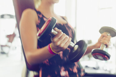 Unscharfe Bewegung bei Bizeps-Curls mit Kurzhanteln im Fitnessstudio - CAIF11706