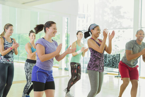 Lächelnde Schüler, die im Aerobic-Kurs klatschen - CAIF11754