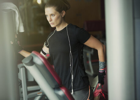 Konzentrierte Frau streckt ihr Bein im Fitnessstudio - CAIF11792