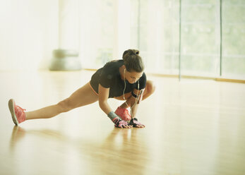 Frau streckt Bein im Fitnessstudio - CAIF11794