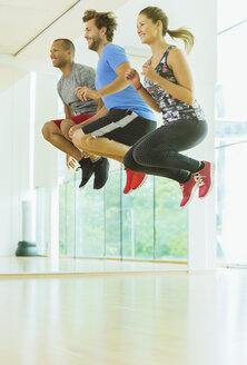 Begeisterte Männer und Frauen springen im Sportunterricht - CAIF11812
