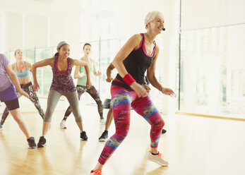 Energetischer Fitnesslehrer, der einen Aerobic-Kurs leitet - CAIF11820