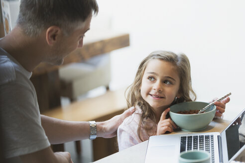Vater und Tochter beim Frühstück am Laptop - CAIF11839