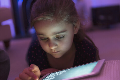 Close up Mädchen spielen Spiel auf digitalen Tablet in der Dunkelheit - CAIF11841