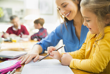 Mother helping daughter with homework - CAIF11862