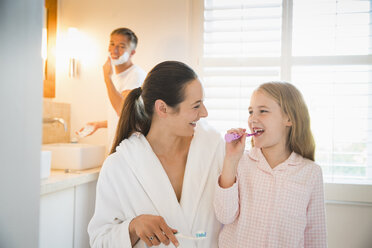 Mutter und Tochter beim Zähneputzen im Badezimmer - CAIF11865