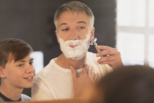 Sohn beobachtet Vater bei der Gesichtsrasur im Badezimmerspiegel - CAIF11898