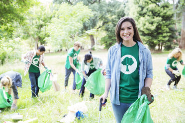 Porträt eines lächelnden Umweltschützers, der freiwillig Müll aufsammelt - CAIF11990