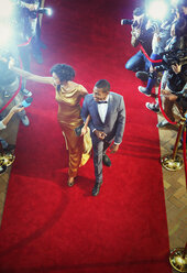 Prominentenpaar, das winkend über den roten Teppich zur Veranstaltung kommt - CAIF12005