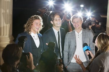 Lächelnde Prominente, die bei einer Veranstaltung von Paparazzi interviewt und fotografiert werden - CAIF12024