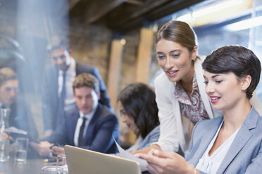 Geschäftsfrauen arbeiten mit einem digitalen Tablet in einem Konferenzraum - CAIF12036