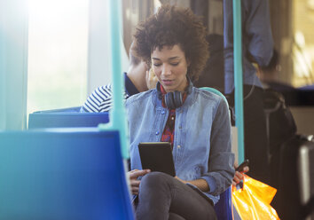 Frau benutzt digitales Tablet im Zug - CAIF12102