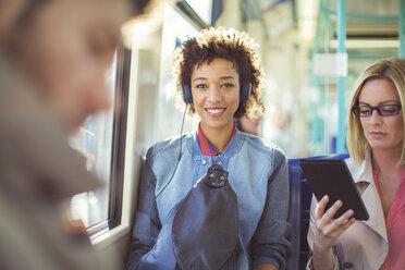 Woman listening to headphones on train - CAIF12113