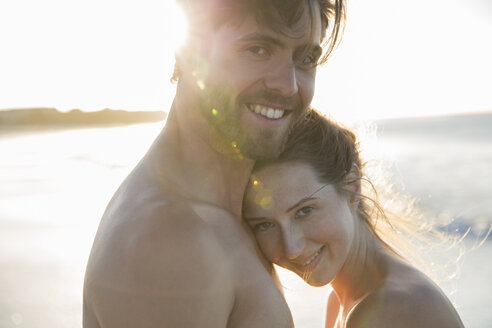 Porträt eines jungen Paares, das sich am Strand umarmt - CAIF12138
