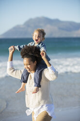 Mother and daughter playing on beach - CAIF12145