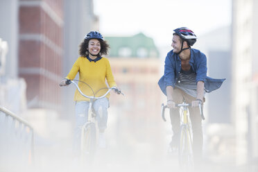 Junges Paar fährt mit dem Fahrrad in der Stadt - CAIF12181